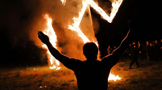 Members of the National Socialist Movement, one of the largest neo-Nazi groups in the US, hold a swastika burning after a rally on April 21, 2018 in Draketown, Georgia. 