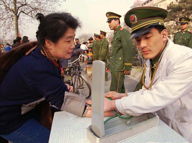 A free health check from an army medic on a Beijing sidewalk on International Women’s Day 1997. Army and other groups offered free haircuts and medical check-ups across Beijing.