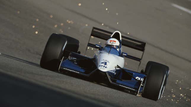 A photo showing sparks flying from the back of a Tyrrell F1 car as it scrapes the ground. 