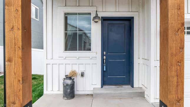 A home's porch with white walls and a dark colored door