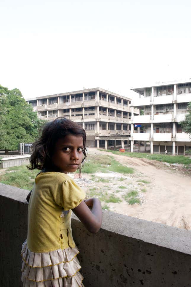 A young girl on an abandoned floor of a commercial block where her family has a makeshift home.
