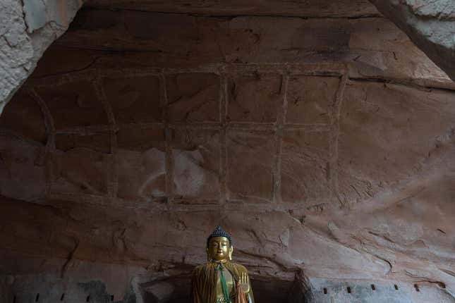 Erosion of the red sandstone cliff body, which has started flaking due to humidity in the No. 3 cave in the Northern Temple of the Mati Temple Cluster.