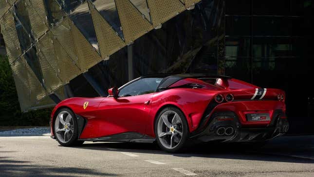 A red Ferrari SP51 Roadster parked under a row of architectural triangles.