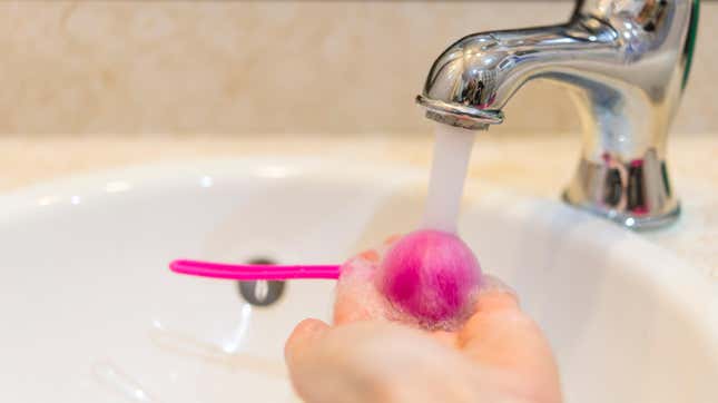 Cleaning a sex toy using running water.