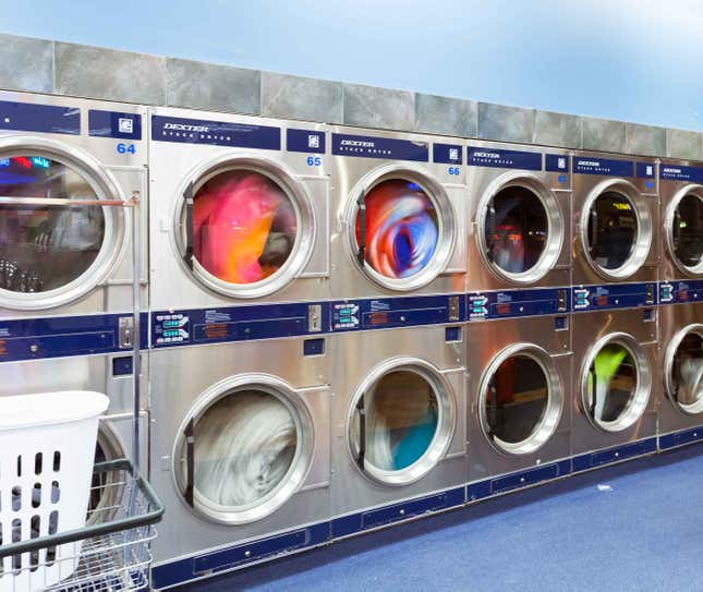 Clothes, sheets and towels spin in the stacked industrial dryers.