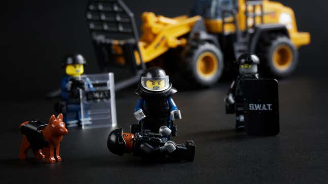 Swat military minifigures - analogue of Lego and forklift on black background. Police or military operation to arrest a criminal or clear a victim.