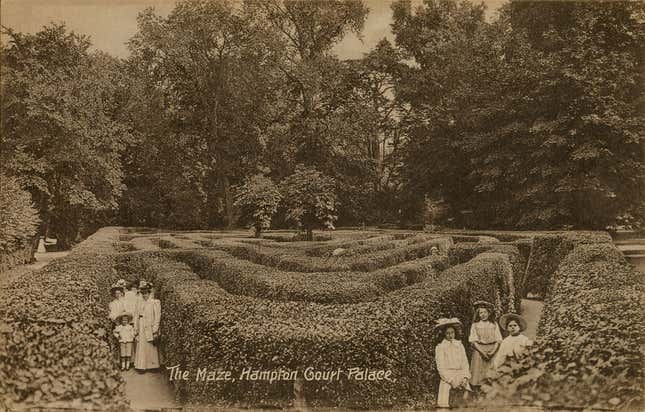 A postcard showing visitors posing in the Maze at Hampton Court Palace