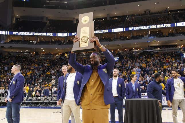 Jan 18, 2023; Milwaukee, Wisconsin, USA;  Former Marquette Golden Eagles player Dwayne Wade holds up the 2003 Division One Semifinalist trophy during a ceremony honoring the 20th anniversary of reaching the Final Four during halftime of the game between the Providence Friars and Marquette Golden Eagles at Fiserv Forum.