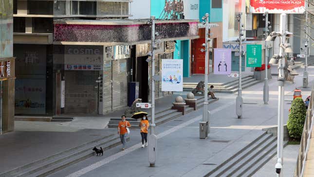 Two people walk by closed stores during lockdown in Shenzhen in south China’s Guangdong province  on March 14, 2022.