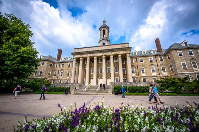 August 31, 2017: Students and adults walk in front of the Old Main building, on the campus of Penn State University, in State College, Pennsylvania.