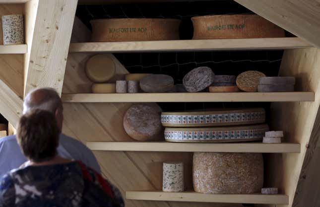 Visitors look at wheels of cheese at the France pavilion