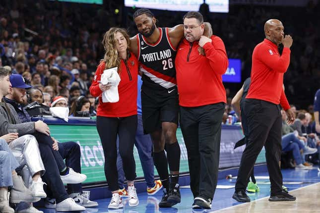 Dec 21, 2022; Oklahoma City, Oklahoma, USA; Portland Trail Blazers forward Justise Winslow (26) is helped off the court after a leg injury during the second half against the Oklahoma City Thunder at Paycom Center. Oklahoma City won 101-98.