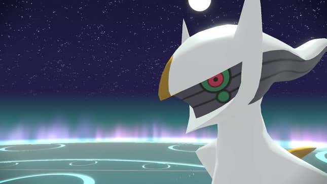 Arceus is seen standing on a lit stage with a night sky behind it.
