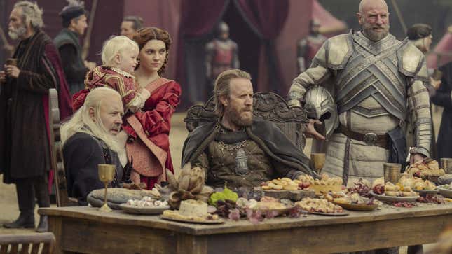 King Viserys, his wife, and the Hand of the King at an elaborate feast.