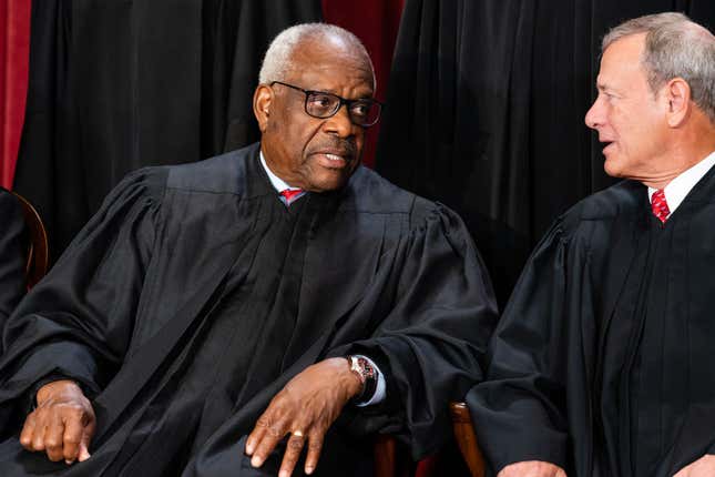 Associate Justice Clarence Thomas, left, talks to Chief Justice John Roberts during the formal group photograph at the Supreme Court in Washington, DC, US, on Friday, Oct. 7, 2022. The court opened its new term Monday with a calendar already full of high-profile clashes, including two cases that could end the use of race in college admissions. 