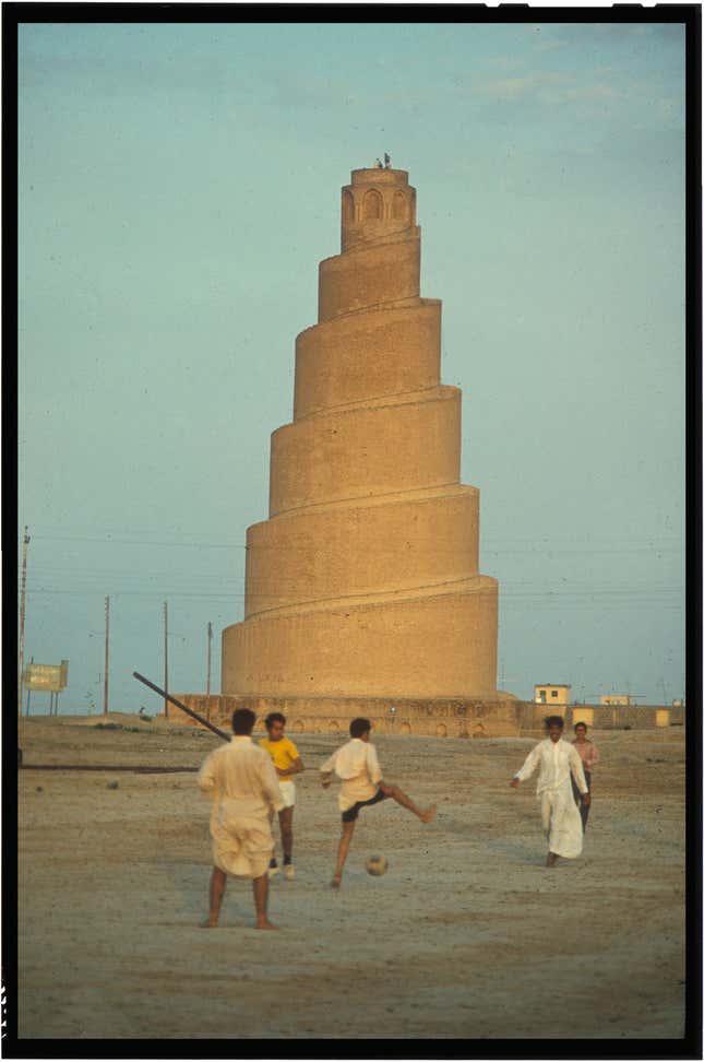 Men play soccer in front of the Great Mosque of Samarra, Baghdadi’s birthplace.