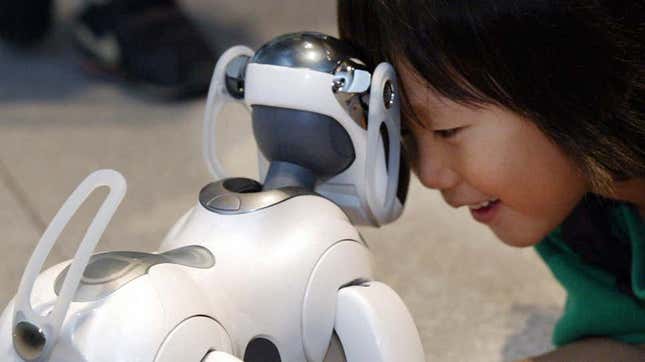 A photo of a kid nuzzling a Sony Aibo 