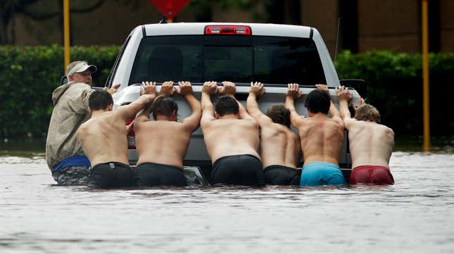 People push a stalled pickup through a flooded street in Houston on Aug. 27.