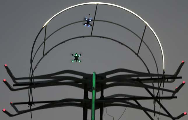 Two small FPV drones flying through a gate at Dubai’s World Drone Prix in March.