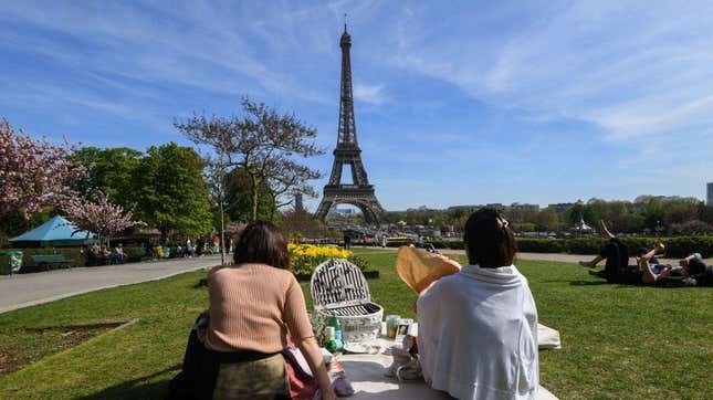 Tourists picnic in front of Eiffel Tower