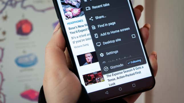 A photo of a person holding up an Android phone with the follow feature available on screen