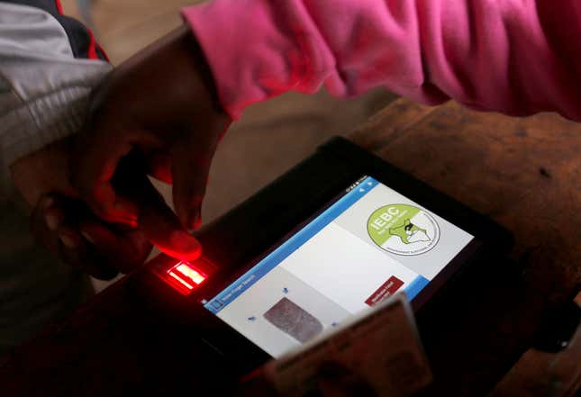 An IEBC official uses an electronic voter identification machine to check a voters' status at a polling station during a presidential election re-run in Nairobi, Kenya October 26, 2017.