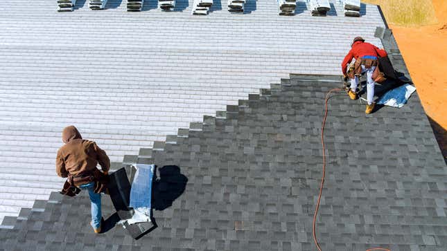 two people installing a new roof on a home