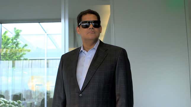 Former head of Nintendo of America, Reggie Fils-Aime walks into a meeting wearing sun glasses. 