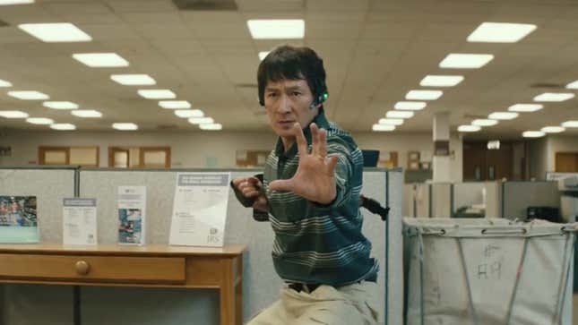 Ke Huy Quan in fighting stance... wearing khakis in the middle of what looks like a boring old office.