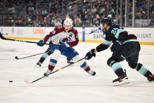 Apr 22, 2023; Seattle, Washington, USA; Colorado Avalanche center Nathan MacKinnon (29) and Seattle Kraken defenseman Jamie Oleksiak (24) fight for the puck during the first period in game three of the first round of the 2023 Stanley Cup Playoffs at Climate Pledge Arena.