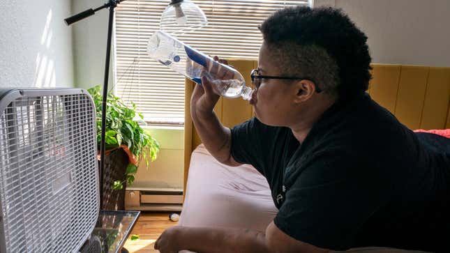 Katherine Morgan drinks water in front of a box fan while trying to stay cool in her downtown apartment without air conditioning on Thursday, Aug. 12, 2021, in Portland, Oregon.