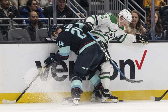 Mar 11, 2023; Seattle, Washington, USA; Seattle Kraken defenseman Jamie Oleksiak (24) and Dallas Stars forward Fredrik Olofsson (42) fight for the puck along the boards during the second period at Climate Pledge Arena.
