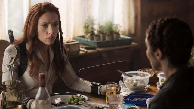 Scarlett Johansson in her white Black Widow outfit in a dinner-table scene from the Marvel Disney movie.
