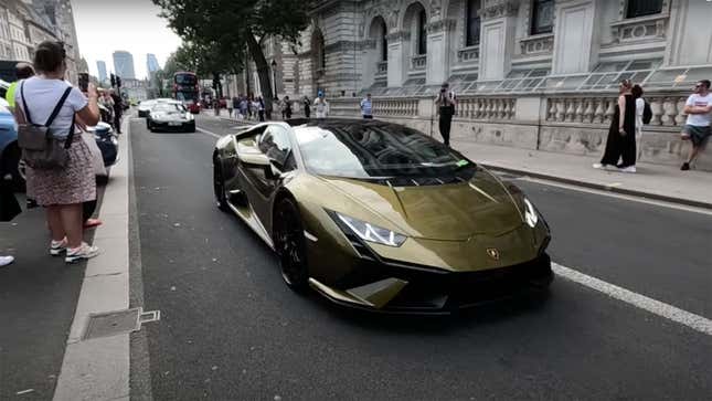 A photo of a beige Lamborghini driving through London. 