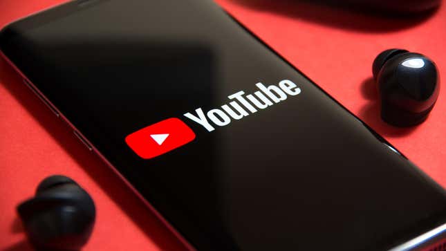 An image of a black phone on a flat surface with the red and white YouTube logo is shown.