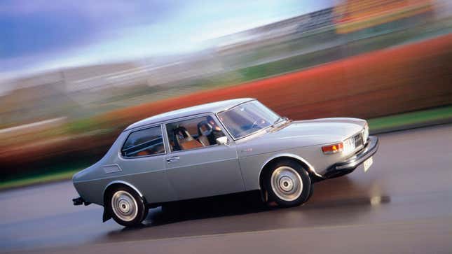 A photo of a 1970s Saab 99 driving on a highway.