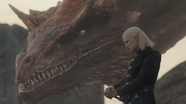 Caraxes the red dragon's huge head looms behind Daemon Targaryen.