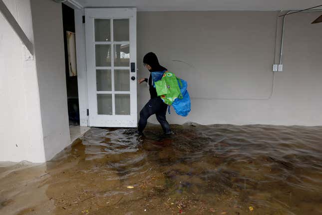 Denis Mendez returns to her flooded home to salvage a few items on April 13, 2023 in Fort Lauderdale, Florida.
