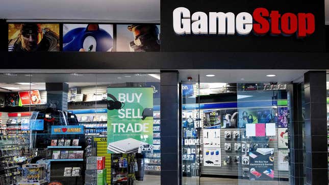A GameStop store sits in a mall with signs for buying and trading consoles. 