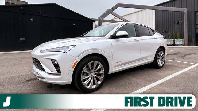 the new white 2024 buick envista four-door compact crossover suv in a parking lot in an industrial-styled setting