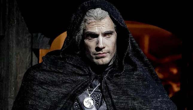 Henry Cavill wears a black cloak and his wolf medallion as Geralt in The Witcher TV series.