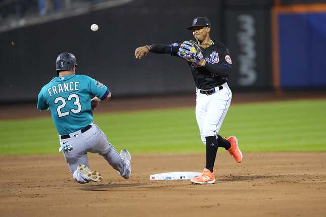Sep 1, 2023; New York City, New York, USA; New York Mets shortstop Francisco Lindor (12) turns a double play with Seattle Mariners first baseman Ty France (23) sliding into second base during the second inning at Citi Field.