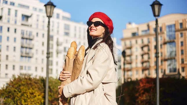 Shopper in red beret holding three baguettes and smiling