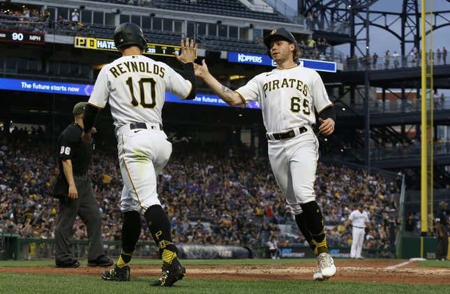 May 19, 2023; Pittsburgh, Pennsylvania, USA;  Pittsburgh Pirates left fielder Bryan Reynolds (10) and center fielder Jack Suwinski (65) high-five after both players scored runs against the Arizona Diamondbacks during the fourth inning at PNC Park.
