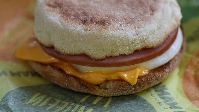 Close-up of an Egg McMuffin from the side, with ham, egg, and melting cheese visible