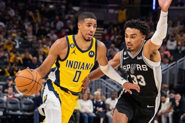 Oct 21, 2022; Indianapolis, Indiana, USA; Indiana Pacers guard Tyrese Haliburton (0) dribbles the ball while San Antonio Spurs guard Tre Jones (33) defends  in the second half at Gainbridge Fieldhouse.