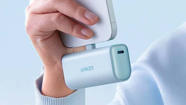 The Anker Nano Power Bank in a baby blue finish attached to the bottom of an iPhone.