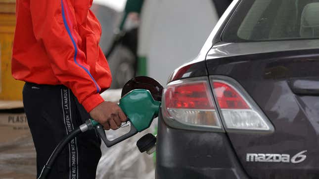 A person fills their car's tank at a gas station.