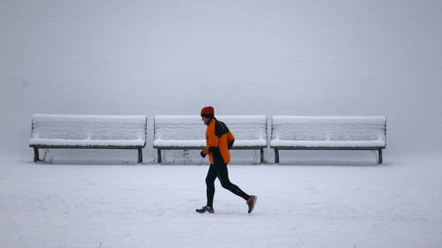 A jogger runs along a snow coverd bank of the Spree river after heavy snowfall in Berlin