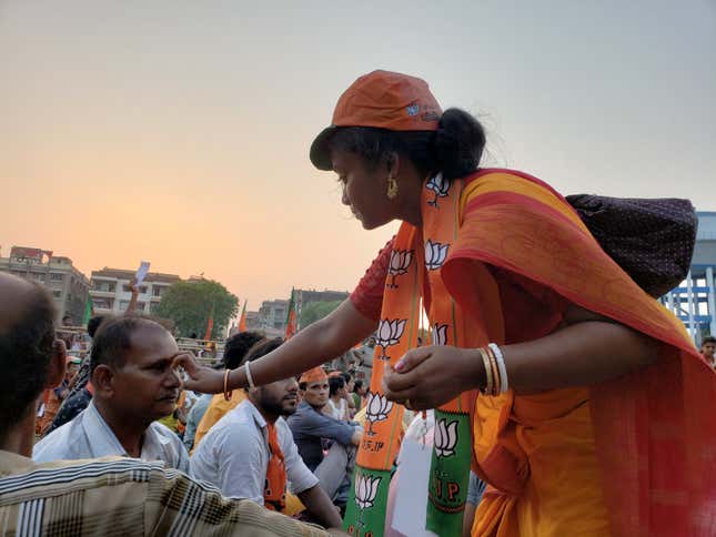 A BJP worker marks the forehead of supporters attending the Modi rally.